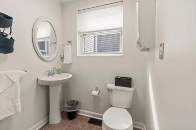 a white bathroom with a toilet and a sink at 3BR Gem in Graduate Hospital in Philadelphia