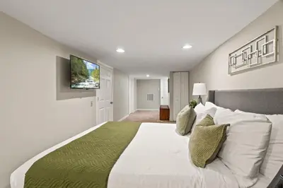 a bedroom with a large bed with a television on the wall at 3BR Gem in Graduate Hospital in Philadelphia