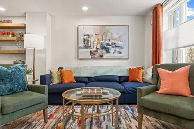 a living room with a blue couch and two chairs at 3BR Gem in Graduate Hospital in Philadelphia