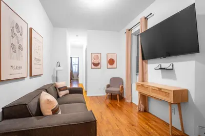 a living room with a couch and a flat screen tv at 2-Bedroom Apartment in Hells Kitchen - Manhattan! in New York