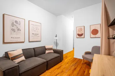 a living room with a couch and a chair at 2-Bedroom Apartment in Hells Kitchen - Manhattan! in New York