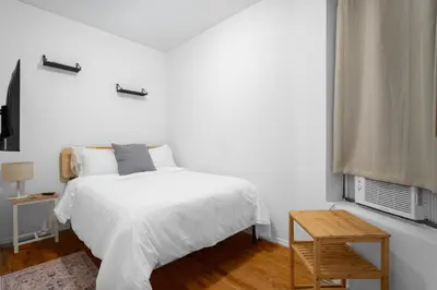 a white bedroom with a bed and a window at 2-Bedroom Apartment in Hells Kitchen - Manhattan! in New York