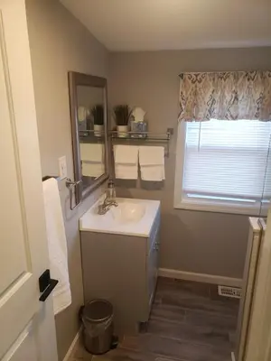 a bathroom with a sink and a mirror and a window at Attractive and Cozy Apartment - 4 bdrms 2 bths in Paterson