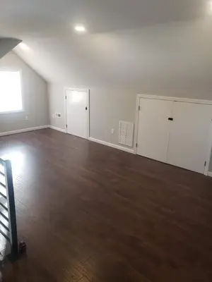 an empty room with white walls and wood floors at Attractive and Cozy Apartment - 4 bdrms 2 bths in Paterson