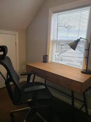 a desk with a lamp and a chair next to a window at Attractive and Cozy Apartment - 4 bdrms 2 bths in Paterson
