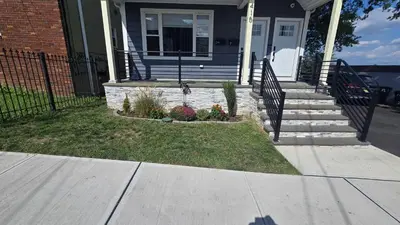 a house with a dog standing on the front porch at Attractive and Cozy Apartment - 4 bdrms 2 bths in Paterson