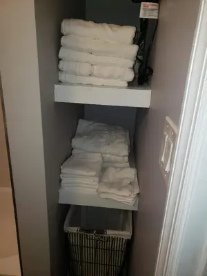 a closet with white towels and a basket of towels at Attractive and Cozy Apartment - 4 bdrms 2 bths in Paterson