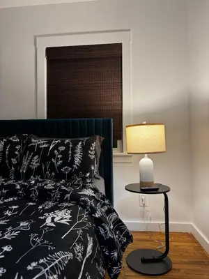 a bedroom with a bed and a table with a lamp at Staten Luxe, Modern Stay Close to NJ, NYC and Brooklyn! in Arlington