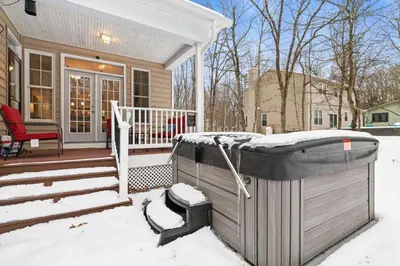 a snow covered house with a hot tub on a porch at Hot Tub Game Room Spacious Close to Skiing in Albrightsville