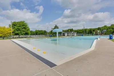 an empty swimming pool with an umbrella in a park at Games, Fire Pit, Hot Tub Pocono Lake Family Home! in Pocono Lake