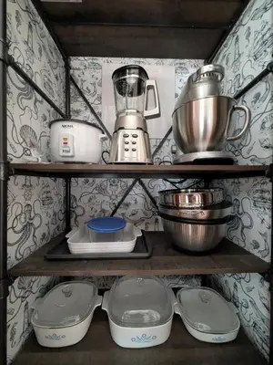 a shelf with pots and pans and a blender at Monster-themed lake front cabin with firepit sauna hot tub game room in Tobyhanna