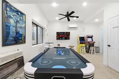 a room with a ping pong table in the middle at Monster-themed lake front cabin with firepit sauna hot tub game room in Tobyhanna