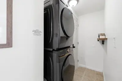 a black refrigerator in a room with a mirror at Monster-themed lake front cabin with firepit sauna hot tub game room in Tobyhanna