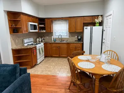 a kitchen with a table and a white refrigerator at Apartment 2 BR near NYC 5min from EWR & 20min from MetLife in Elizabeth