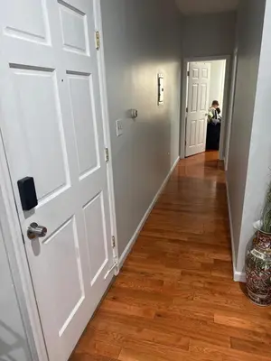 a hallway with a white door and wooden floors at Apartment 2 BR near NYC 5min from EWR & 20min from MetLife in Elizabeth