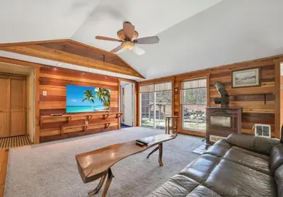 a living room with a couch and a flat screen tv at Serenity at Moon Lake Hot Tub Sauna Massage in Ashland