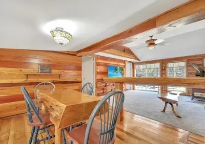 a dining room with a wooden table and chairs at Serenity at Moon Lake Hot Tub Sauna Massage in Ashland