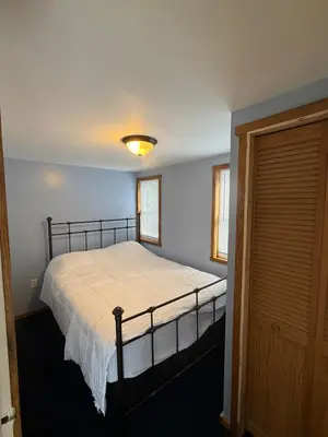 a bedroom with a bed with a white bedspread at Serenity at Moon Lake Hot Tub Sauna Massage in Ashland