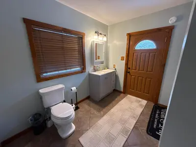 a bathroom with a toilet and a sink and a door at Serenity at Moon Lake Hot Tub Sauna Massage in Ashland