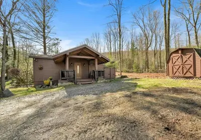 a home with a garage and a barn at Serenity at Moon Lake Hot Tub Sauna Massage in Ashland