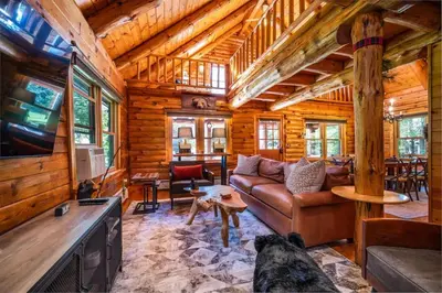 a living room with a couch and a tv in a cabin at Authentic Log Cabin Short walk to Lake & Hideout in Lake Ariel