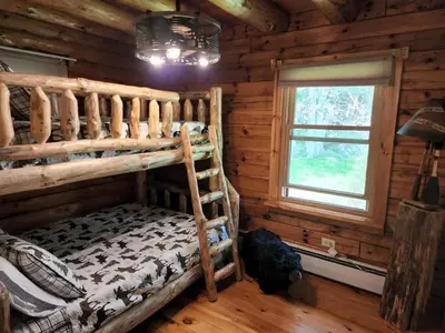 a bedroom with a bunk bed in a log cabin at Authentic Log Cabin Short walk to Lake & Hideout in Lake Ariel