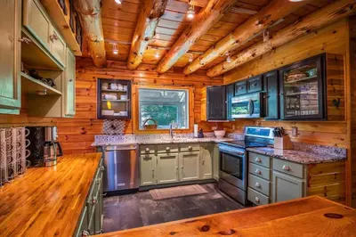 a kitchen with wooden walls and a wooden ceiling at Authentic Log Cabin Short walk to Lake & Hideout in Lake Ariel