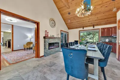 a dining room with a table and a fireplace at Big Bass Hideaway with Hot Tub in Gouldsboro