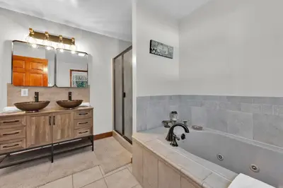 a bathroom with two sinks and a bath tub at Big Bass Hideaway with Hot Tub in Gouldsboro