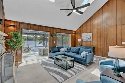 a living room with a blue couch and a ceiling fan at Lakefront Big Bass Lake Dock Games in Gouldsboro