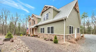 a house with a flag on the side of it at 6 Bedrooms Hot Tub Game Room Movie Theater in Hawley