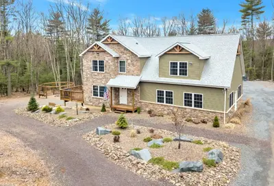 a home with a stone house with a driveway at 6 Bedrooms Hot Tub Game Room Movie Theater in Hawley