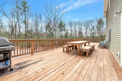 a wooden deck with a picnic table and a grill at 6 Bedrooms Hot Tub Game Room Movie Theater in Hawley