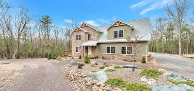 a house on a road in the woods at 6 Bedrooms Hot Tub Game Room Movie Theater in Hawley