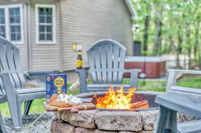 a fire pit with hot dogs and a box and chairs at Hot Tub Game Room Firepit Arrowhead Family in Thornhurst