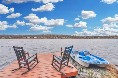 two chairs and a boat on a dock at Lakefront Hot Tub Kayaks High End Peaceful in Tobyhanna