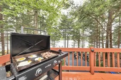 a grill on a deck with eggs on it at Lakefront Hot Tub Kayaks High End Peaceful in Tobyhanna