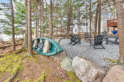 a kayak sitting on a gravel patio with trees at Lakefront Hot Tub Kayaks High End Peaceful in Tobyhanna
