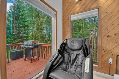 a black chair sitting on a deck with a grill at Lakefront AC Pool Table Kayaks Refined in Tobyhanna