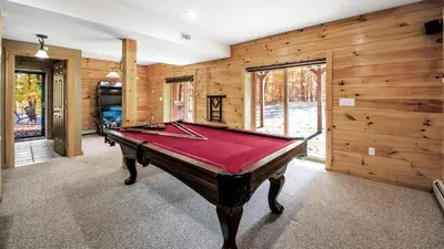 a pool table in a room with wooden walls at Massive Log Chalet with Hot Tub in Lakeville
