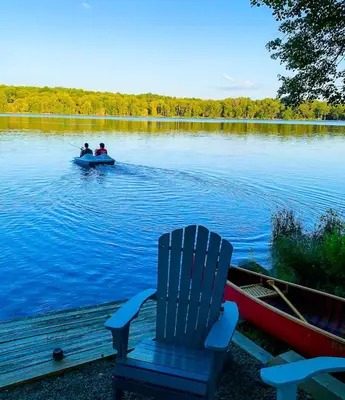 two people in a boat on a lake at Lakefront Hot Tub Canoes Game Room Wood FP in Gouldsboro