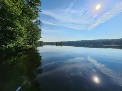 a large body of water with trees on the shore at Lakefront Hot Tub Canoes Game Room Wood FP in Gouldsboro