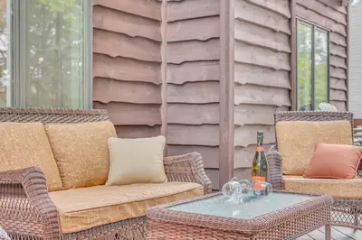 a patio with two chairs and a table with a bottle of wine at Large Family Friendly House on the Fairway Hideout in Lakeville
