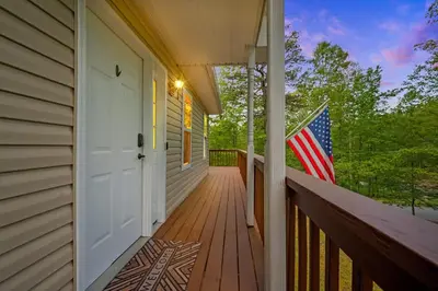 a porch with an american flag on a house at The Lookout Lake Masthope Firepit Arcade in Lackawaxen