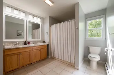 a bathroom with a toilet and a sink and a window at The Lookout Lake Masthope Firepit Arcade in Lackawaxen