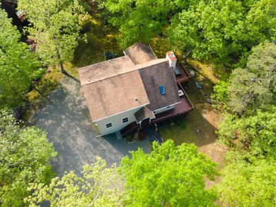 an overhead view of a house in the middle of trees at The Lookout Lake Masthope Firepit Arcade in Lackawaxen