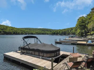 a boat tied up to a dock on a lake at Lake Wallenpaupack Lakefront Private Boat Slip in Greentown