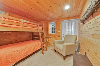 a bedroom with a bunk bed and a chair at Lake Wallenpaupack Lakefront Private Boat Slip in Greentown