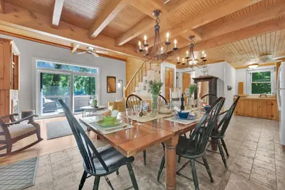 a dining room with a wooden table and chairs at Lake Wallenpaupack Lakefront Private Boat Slip in Greentown