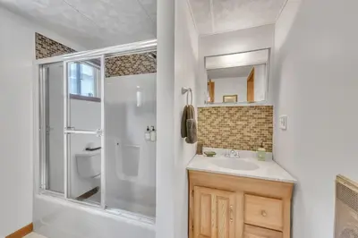 a white bathroom with a shower and a sink at Lakefront Views 5 Bdrm Kayaks Out Kitchen in Lake Ariel